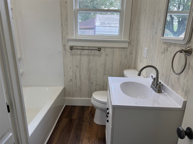 bathroom featuring wood walls, hardwood / wood-style floors, vanity, and toilet