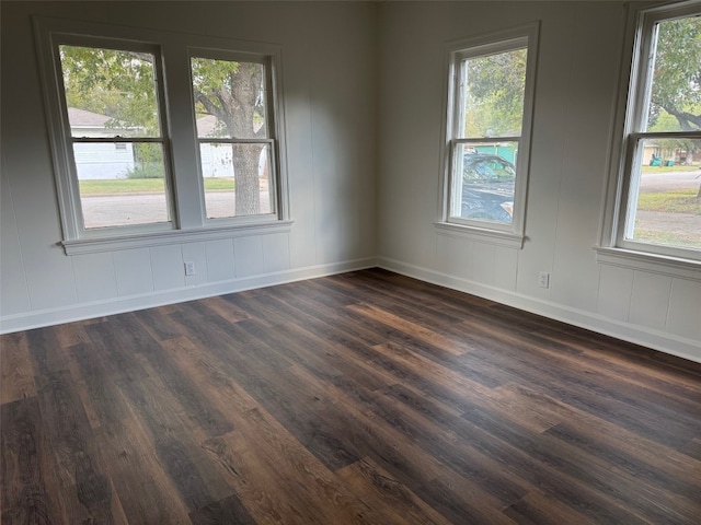 unfurnished room featuring a healthy amount of sunlight and dark hardwood / wood-style floors