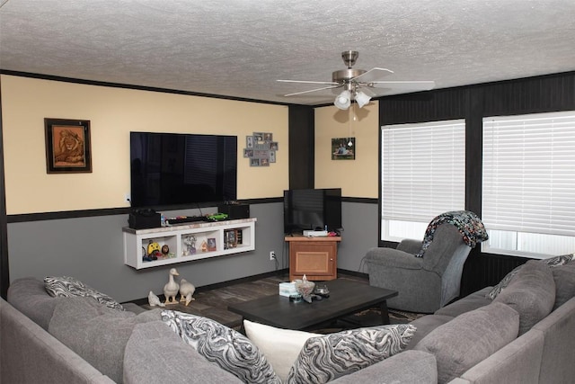 living room featuring baseboards, a ceiling fan, a textured ceiling, and wood finished floors