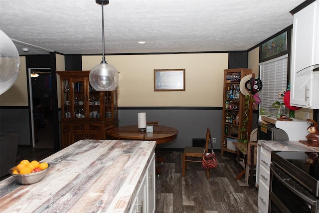 kitchen featuring a textured ceiling, dark wood-style floors, wooden counters, and white cabinetry