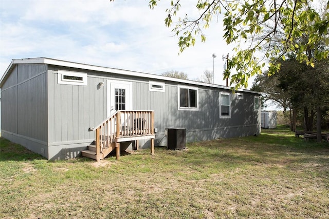 back of property with a lawn and cooling unit