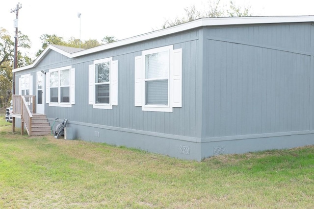 view of side of property featuring a yard and crawl space