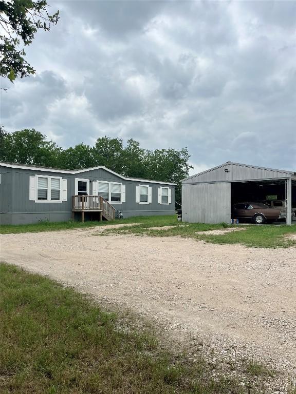 view of front of home with a pole building, an outbuilding, and driveway