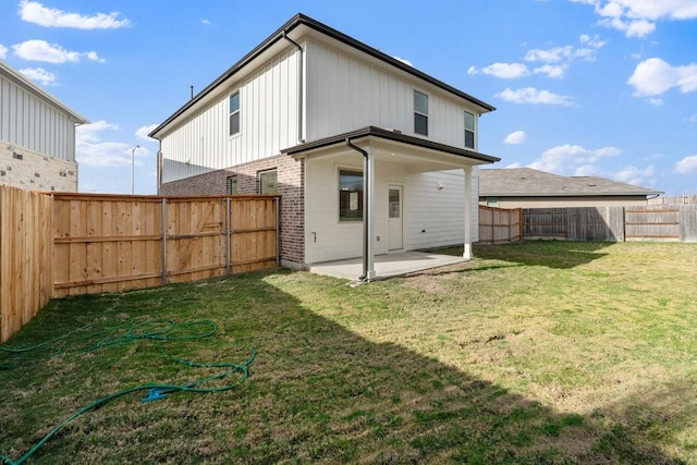 back of house featuring a patio area and a yard