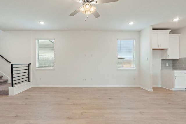 unfurnished living room with plenty of natural light, ceiling fan, and light wood-type flooring