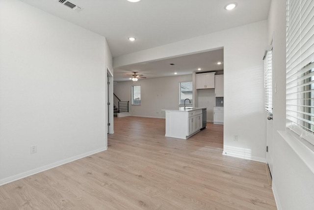 unfurnished living room featuring sink and light hardwood / wood-style flooring