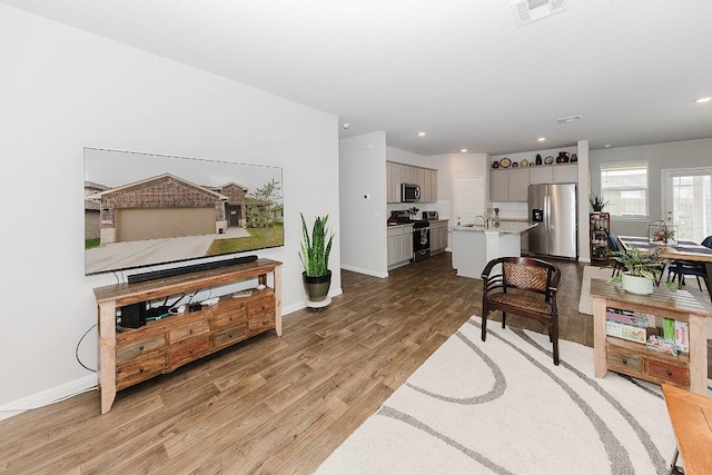 living room with sink and light hardwood / wood-style flooring