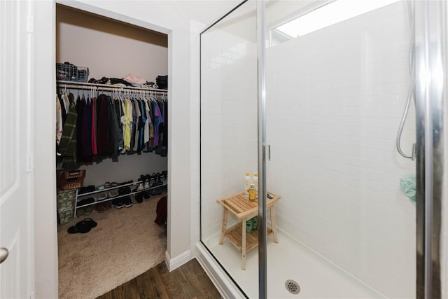 bathroom with an enclosed shower and hardwood / wood-style floors