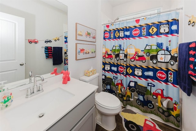 bathroom featuring a shower with curtain, vanity, and toilet