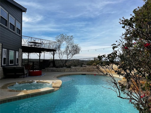 view of swimming pool with an in ground hot tub