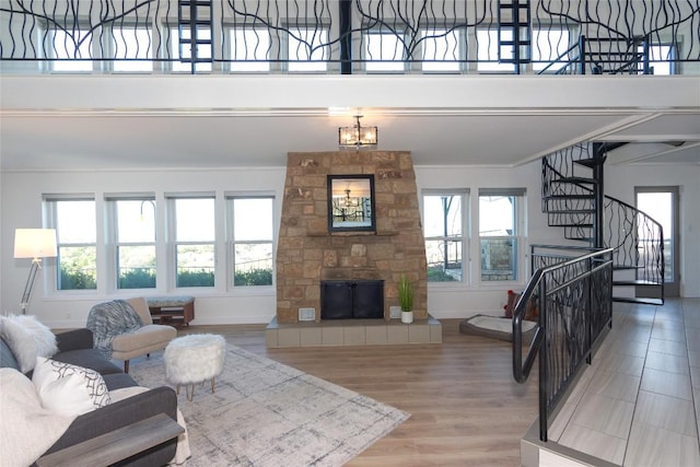 living room with a notable chandelier, wood-type flooring, and a fireplace