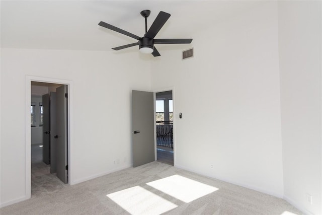 unfurnished bedroom featuring ceiling fan, light colored carpet, and lofted ceiling