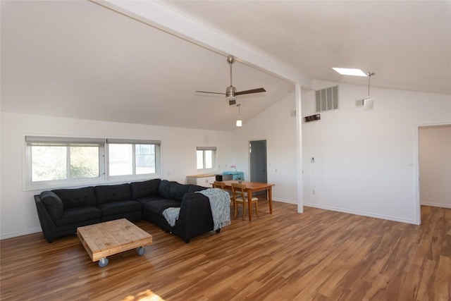 living room featuring a skylight, ceiling fan, beamed ceiling, high vaulted ceiling, and hardwood / wood-style floors