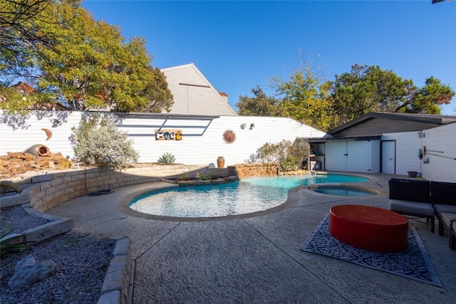 view of pool with an in ground hot tub, a patio area, and a storage shed