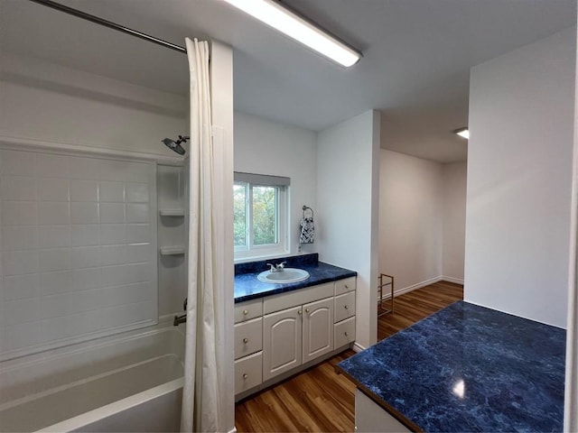 bathroom with wood-type flooring, vanity, and shower / washtub combination