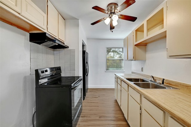 kitchen featuring cream cabinets, sink, black appliances, and light wood-type flooring