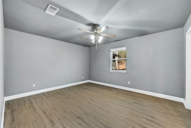 unfurnished room with ceiling fan, wood-type flooring, and a textured ceiling