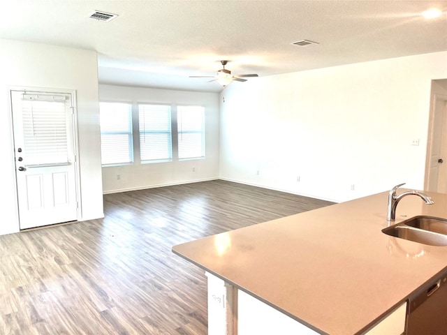 kitchen with dishwasher, sink, hardwood / wood-style flooring, ceiling fan, and a textured ceiling