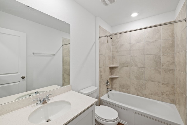 full bathroom with toilet, vanity, and tiled shower / bath