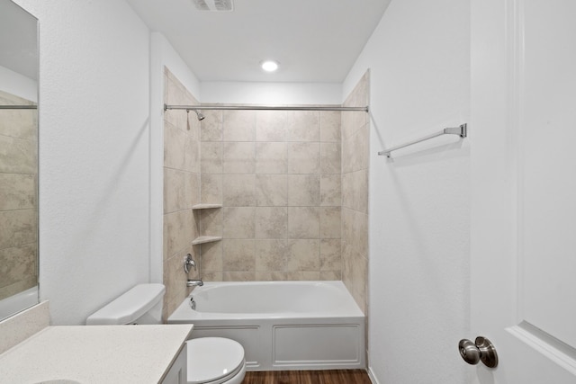 full bathroom with vanity, hardwood / wood-style floors, tiled shower / bath combo, and toilet