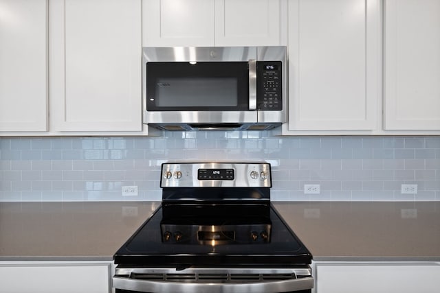 kitchen featuring white cabinets, stainless steel appliances, and tasteful backsplash