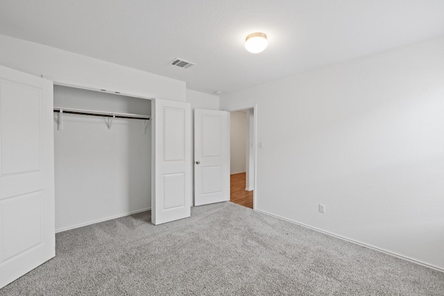 unfurnished bedroom featuring carpet and a closet