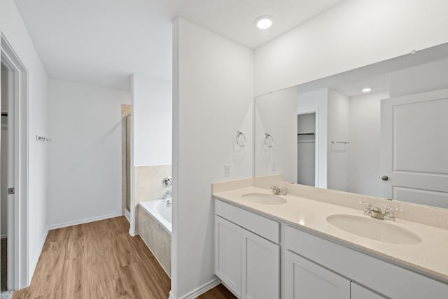 bathroom featuring hardwood / wood-style floors, vanity, and shower with separate bathtub