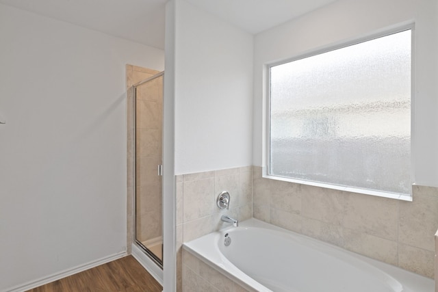 bathroom with hardwood / wood-style floors and independent shower and bath