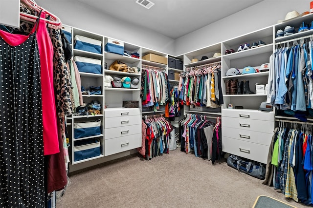 walk in closet with light colored carpet