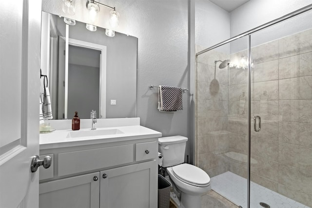 bathroom featuring vanity, an enclosed shower, and toilet