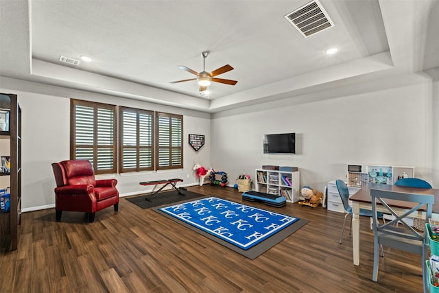 rec room featuring hardwood / wood-style floors, ceiling fan, and a tray ceiling