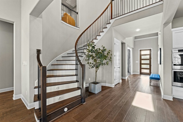 staircase featuring a high ceiling and wood-type flooring