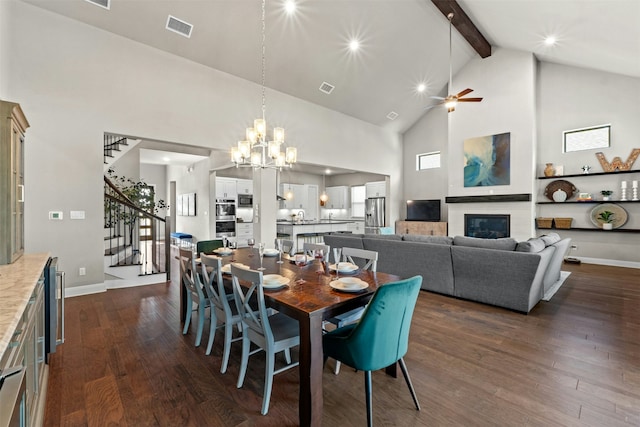 dining space featuring beamed ceiling, high vaulted ceiling, ceiling fan with notable chandelier, and dark wood-type flooring