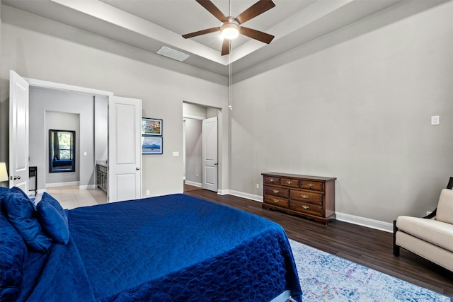 bedroom featuring a raised ceiling, wood-type flooring, and ceiling fan