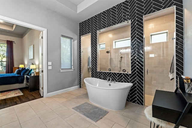 bathroom featuring a tray ceiling, tile patterned floors, plus walk in shower, and tile walls