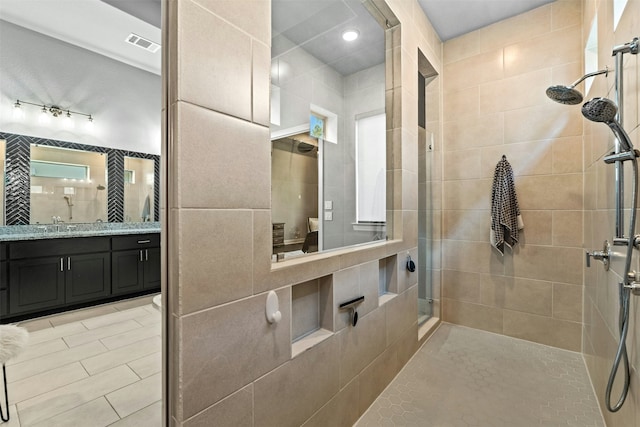 bathroom with vanity and tiled shower