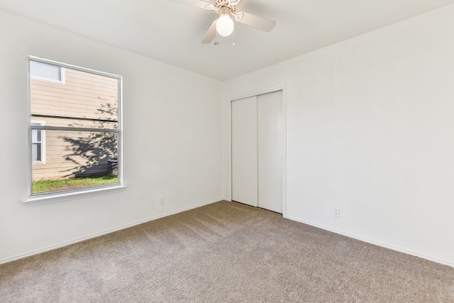 unfurnished bedroom featuring carpet floors, a closet, and ceiling fan