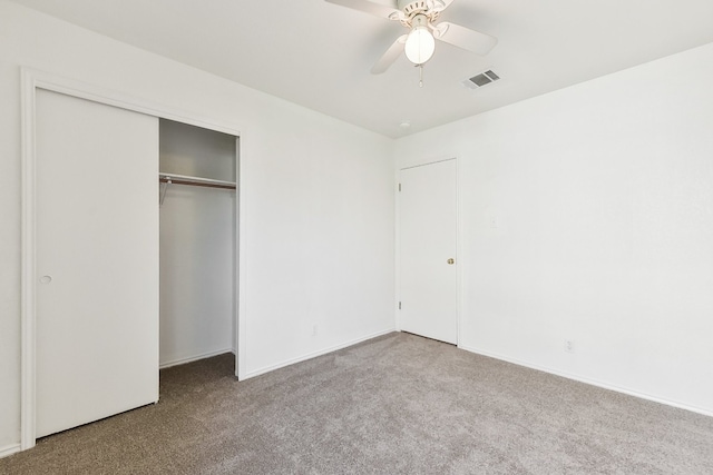 unfurnished bedroom with ceiling fan, light colored carpet, and a closet