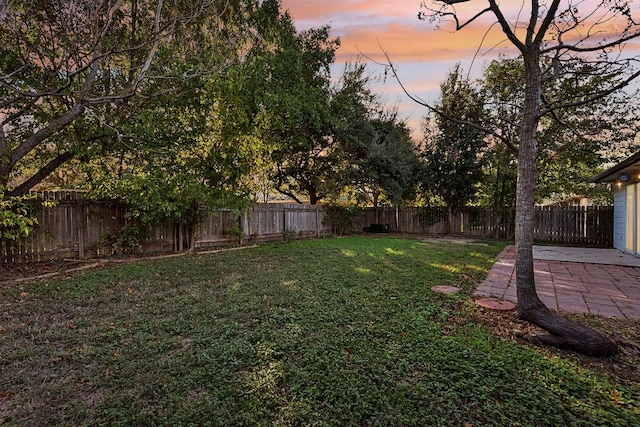 yard at dusk featuring a patio