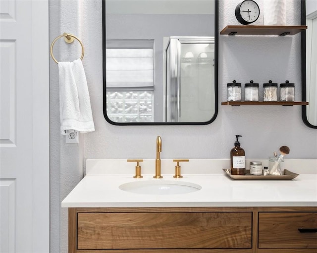 bathroom featuring vanity and a shower with door