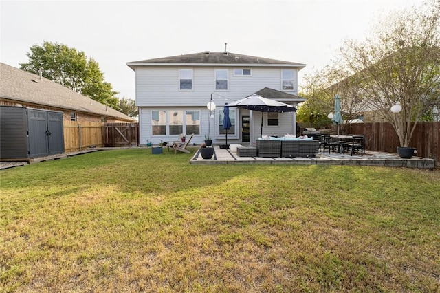 back of house featuring a shed, a lawn, an outdoor hangout area, and a patio