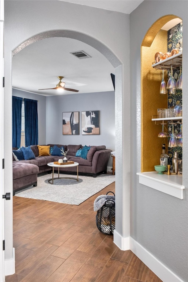 living room with ceiling fan and wood-type flooring