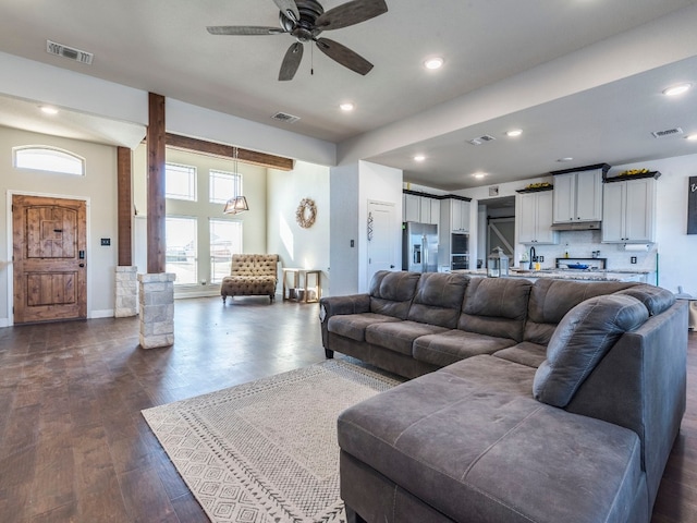 living room with ceiling fan and dark hardwood / wood-style flooring