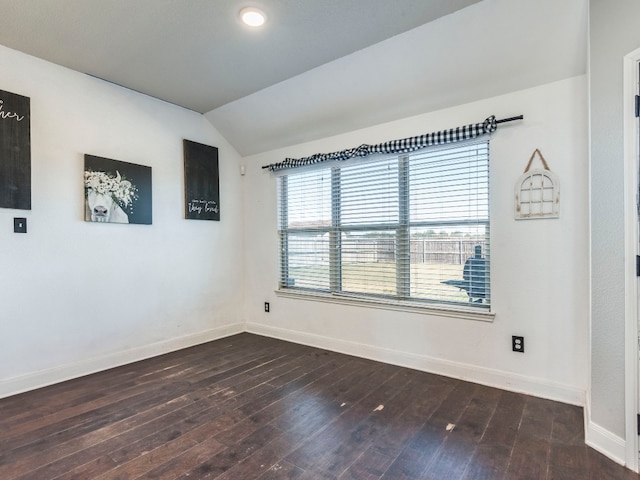 empty room with dark hardwood / wood-style flooring and lofted ceiling