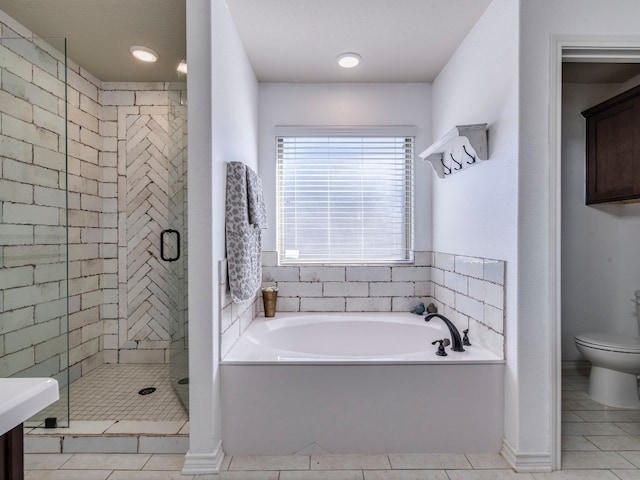 bathroom with toilet, shower with separate bathtub, and tile patterned floors