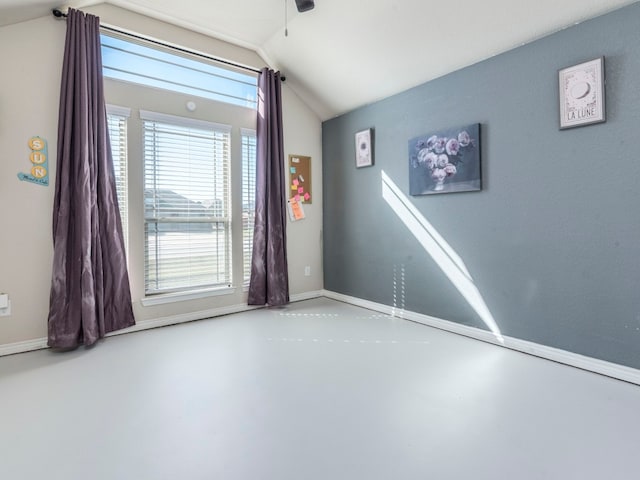 unfurnished room with concrete floors and vaulted ceiling