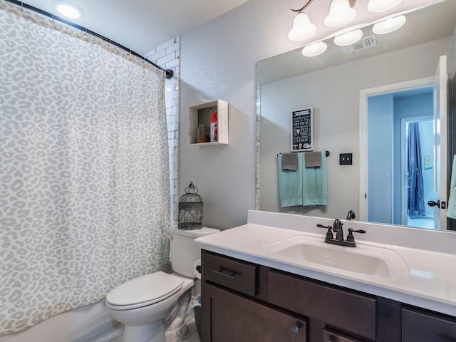 full bathroom featuring shower / bath combo, vanity, and toilet