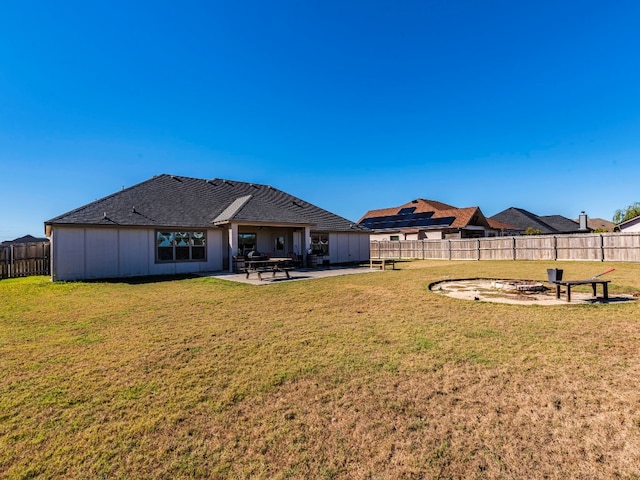 back of house featuring a yard, a patio, and an outdoor fire pit