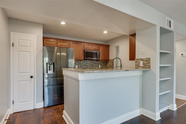 kitchen with backsplash, dark hardwood / wood-style flooring, kitchen peninsula, and stainless steel appliances