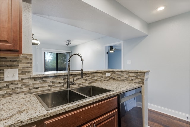 kitchen with decorative backsplash, sink, dark wood-type flooring, and black dishwasher